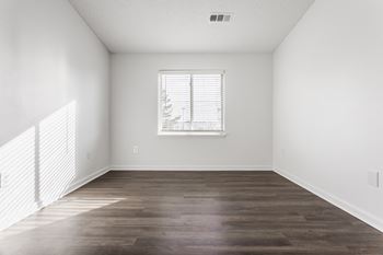 an empty living room with white walls and a window at Polo Run Apartments, Greenwood, Indiana